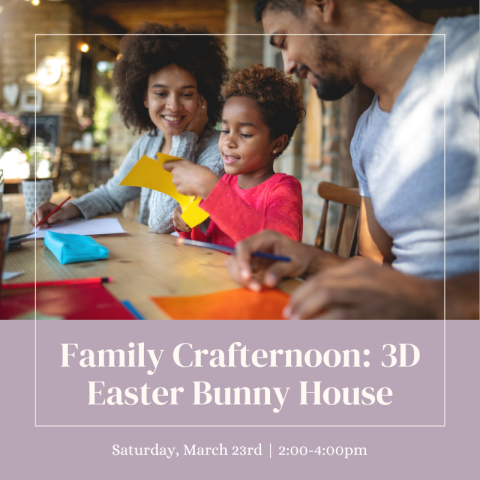 A father, mother, and son sitting together at a table while doing a craft.