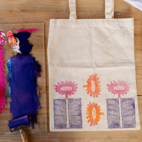 A tote bag being decorated with paint.