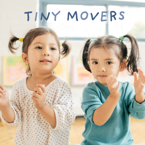 Two little girls dancing side by side.