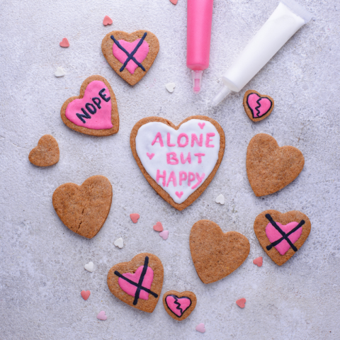 Heart-shaped cookies decorated with anti-valentine's day phrases.