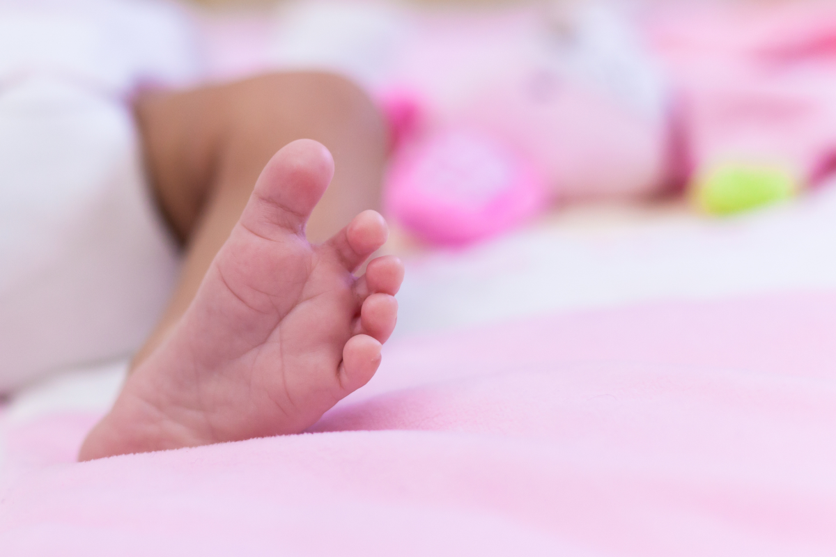 african american baby foot on pink blanket