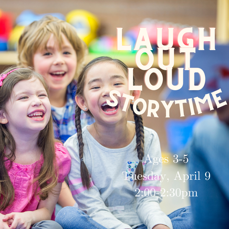 A group of laughing children sitting on the ground being read aloud to.