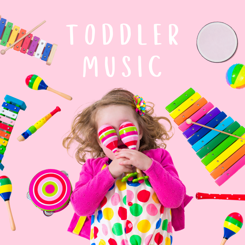 A little girl surrounded by a variety of musical instruments, including a xylophone and a tambourine.